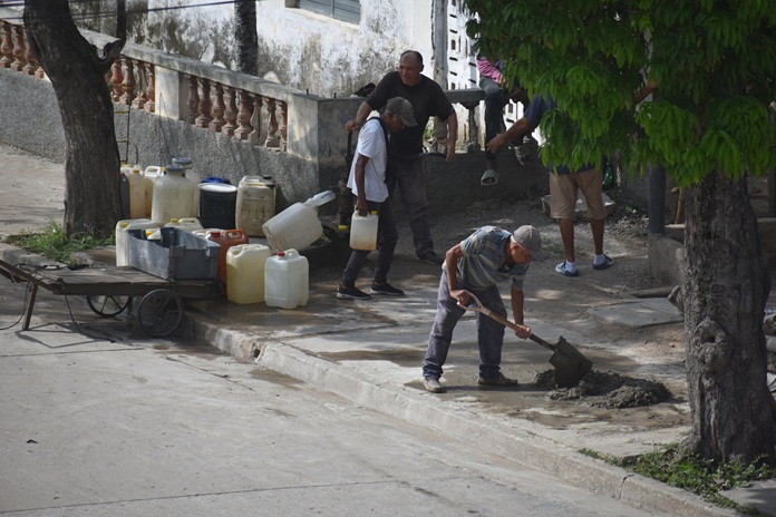 Del día a día 2 hombre batiendo mezclas y otros cargando agua